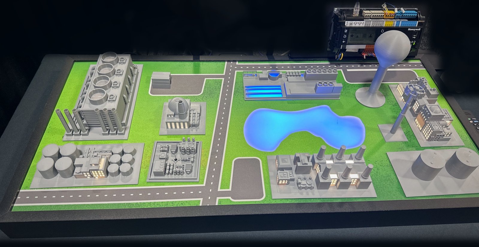 Tabletop model with power plant, tank farm, glowing reservoir, and treatment facility